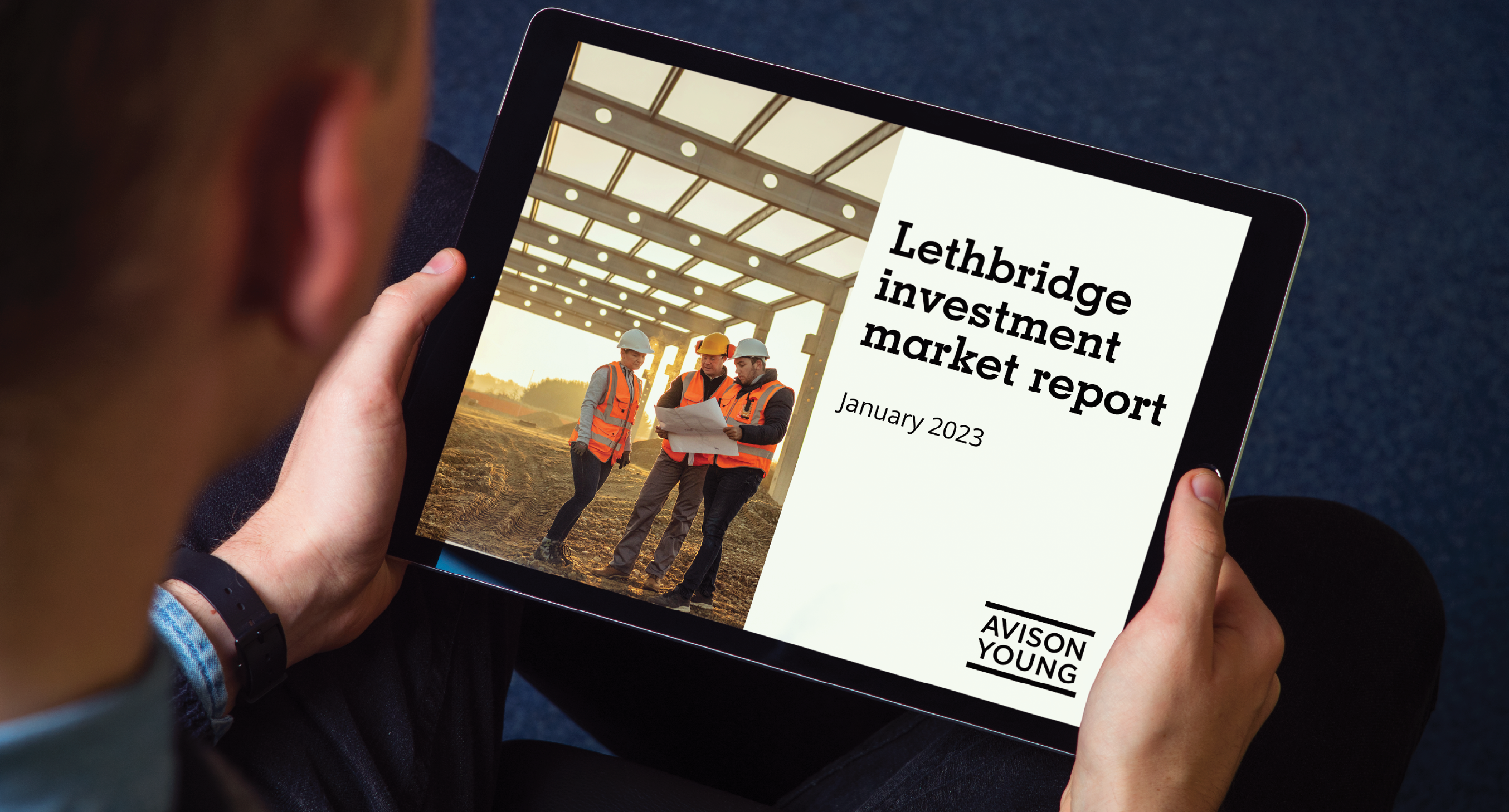 person holding a tablet displaying the January 2023 Lethbridge investment market report