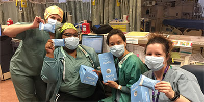 medical staff wearing masks hold packages