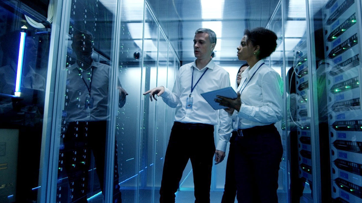 colleagues in a data center discuss a server