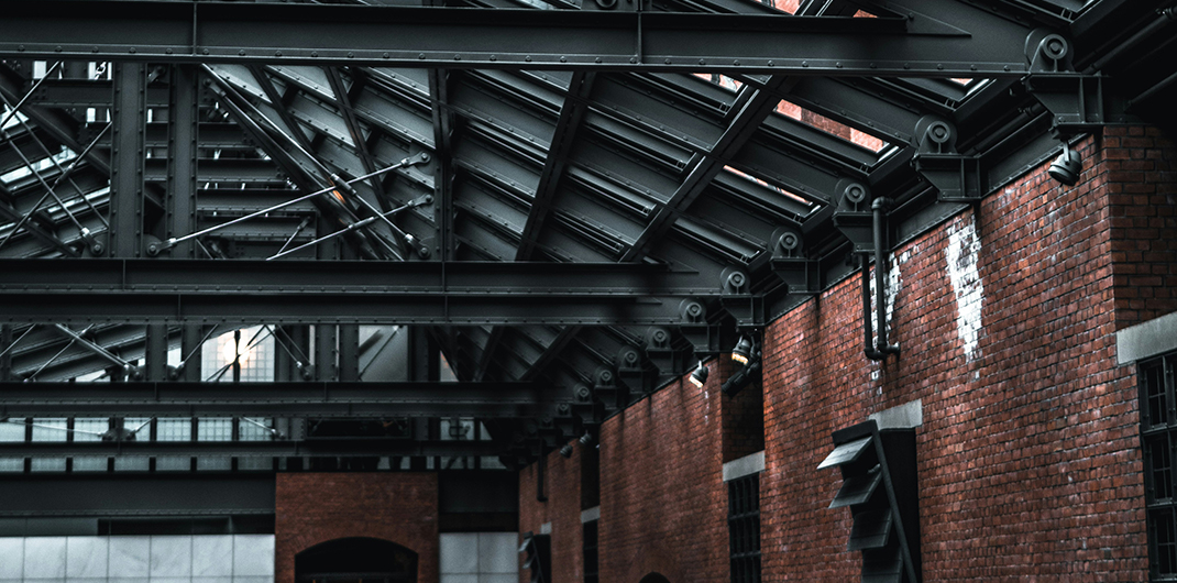interior view of a renovated industrial property with brick walls and iron ceiling girders