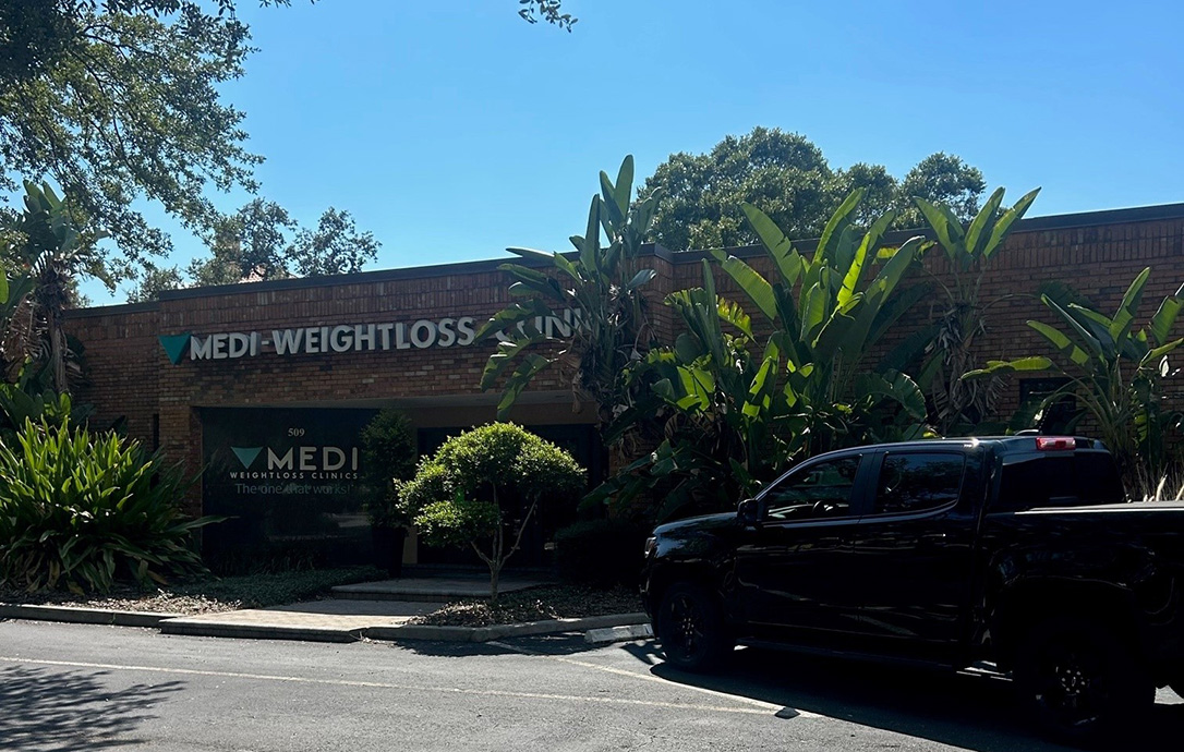 Brick medical office building surrounded by palm trees with medi-weightloss clinic sign on the front in Tampa, Florida