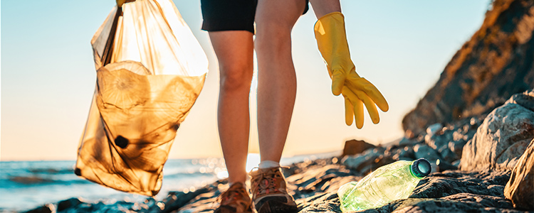 Image of a person picking up litter on a beach